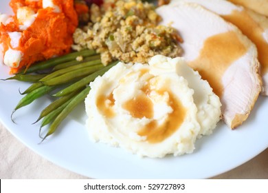 Thanksgiving Meal With Turkey, Mashed Potatoes, Stuffing, Green Beans And Yams With Marshmallows And Gravy