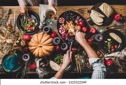 Thanksgiving party table setting. Flat-lay of couple eating and drinking champagne at table with roasted chicken, vegetables, fig pie, fruit, candles over rustic wooden table background, top view - Shutterstock ID 1525522349