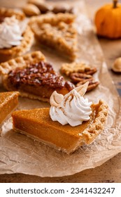 Thanksgiving pies slices on parchment paper, pumpkin and pecan pie