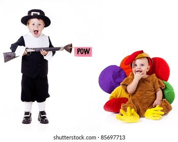 Thanksgiving; Pilgrim child pretending to shoot baby dressed in silly turkey costume with a toy rifle