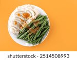 Thanksgiving plate with mashed potatoes and green beans, with gravy sauce on it, festive holiday dinner foods