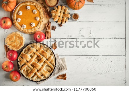 Thanksgiving pumpkin and apple various pies on white, top view, copy space. Fall traditional homemade apple and pumpkin pie for autumn holiday.