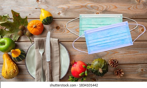 Thanksgiving table menu, coronavirus days, COVID 19 protective mask and thanksgiving place setting on wooden background. Corona virus prevention measure, top view