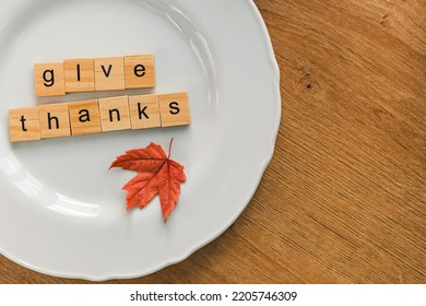 Thanksgiving Table Setting Concept. Small Red Leaf And Text Give Thanks On The White Plate