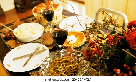 Thanksgiving table spread, macaroni and cheese, pumpkin pie, bread rolls, red wine glasses, fall foliage centerpiece, autumn colors, Thanksgiving feast, casual dining, harvest celebration - Powered by Shutterstock