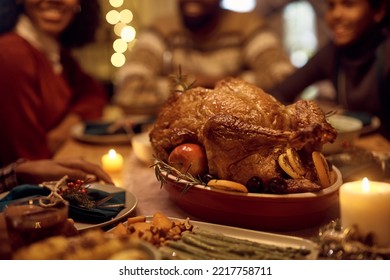 Thanksgiving Turkey At Dining Table With Extended Black Family In  The Background.