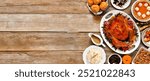 Thanksgiving turkey dinner. Above view side border on a rustic wood table banner background. Turkey, mashed potatoes, stuffing, pumpkin pie and sides.