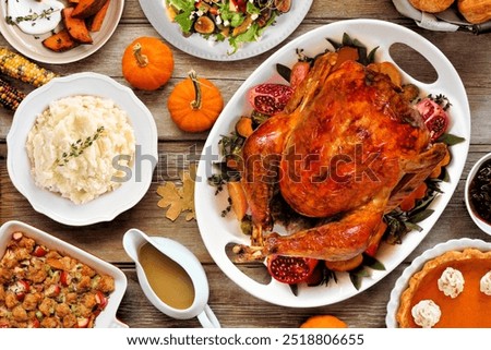 Thanksgiving turkey dinner. Overhead view table scene on a rustic wood background. Turkey, mashed potatoes, stuffing, pumpkin pie and sides.