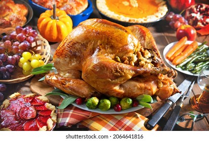 Thanksgiving Turkey Dinner. Roasted Turkey On Holiday Table With Pumpkins, Pie, Fruits, Flowers And Wine