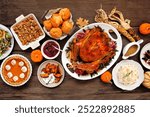 Thanksgiving turkey dinner. Top down view table scene on a rustic wood background. Turkey, mashed potatoes, stuffing, pumpkin pie and sides.