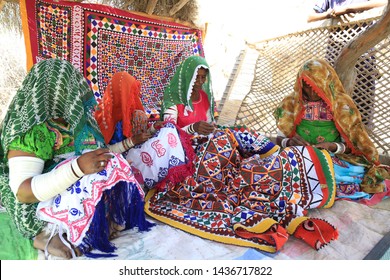 Tharparkar Sindh, Pakistan - March, 2019: Thar Woman Sewing Traditional Bed Sheets In Colourful Dress Sitting On Ground Inside Their Rural House, Women Smiling Happy Faces Rajhastan Desert