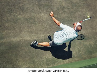 That Was Close. High Angle Shot Of A Focused Middle Aged Man Playing Tennis Outside On A Tennis Court During The Day.