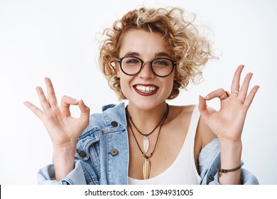 That deal, okay I agree. Portrait of satisfied positive and charismatic happy young female showing ok signs and smiling in approval, recommend awesome salon as liking new haircut over white background