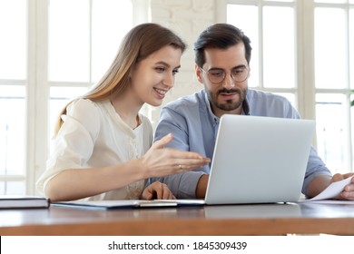 That Is How It Works. Smiling Businesswoman Experienced In Work On Business Project Training Coaching Man Coworker, Pleasant Lady Qualified Consultant Advisor Assisting Male Client Customer At Laptop