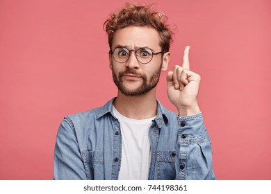That is! Handsome clever student wonk or geek wears round glasses, raises finger as understands new theory, going to prove it, looks confidently, isolated over pink background. Confidence concept - Shutterstock ID 744198361