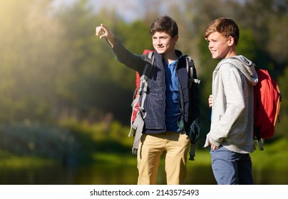 That looks like the perfect camping spot over there. Shot of two young boys wearing backpacks exploring nature together. - Shutterstock ID 2143575493