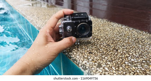 Action​ camera​ on​ hand​ ​of​ man​ that in​ swimming​ ​pool.​ water​ proof camera.