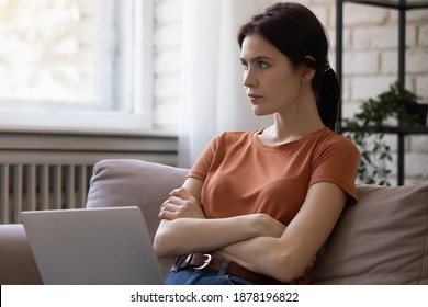 That is a question. Pensive millennial lady sit on couch at home using laptop planning remote work, Thoughtful female distracted from pc screen holding hands crossed. Young woman thinking on problem - Shutterstock ID 1878196822