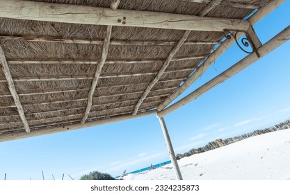 Thatch of dried grass. A surface composed of blades of grass placed on a wooden structure. Background of dried grass.