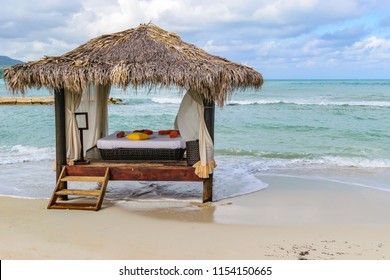 Thatch Roof Hut Massage Bed On Tropical Caribbean Island White Sand Beach. Luxury Vacation Resort Spa Pampering. Montego Bay, Jamaica.