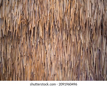 Thatched Grass Wall Closeup.  Coral and rose toned dry woven bamboo grass close up with room for copy or message over.