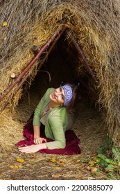 Thatched Hut In The Autumn Forest. Cabin In The Countryside. Happy Woman Is Resting In Nature. Escape From The Bustle Of The City To Nature.