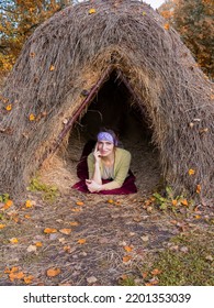 Thatched Hut In The Autumn Forest. Cabin In The Countryside. Happy Woman Is Resting In Nature. Escape From The Bustle Of The City To Nature.