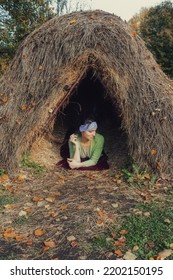 Thatched Hut In The Autumn Forest. Cabin In The Countryside. Happy Woman Is Resting In Nature. Escape From The Bustle Of The City To Nature.