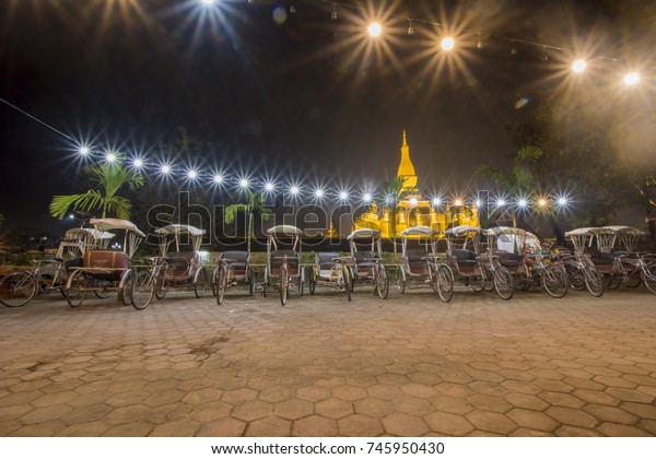 Thatluang stupa with\
three wheel car at\
night