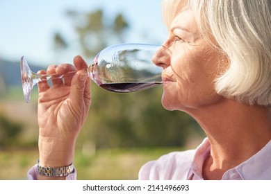 Thats a fine vintage. Closeup shot of a senior woman drinking a glass of red wine outside. - Powered by Shutterstock