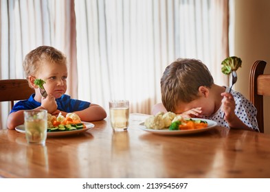 Thats it, were going on a hunger strike. Shot of two unhappy little boys refusing to eat their vegetables at the dinner table.