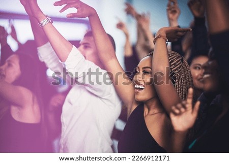 Thats my favourite song. Cropped shot of an attractive young woman cheering while standing in the crowd at a concert at night.