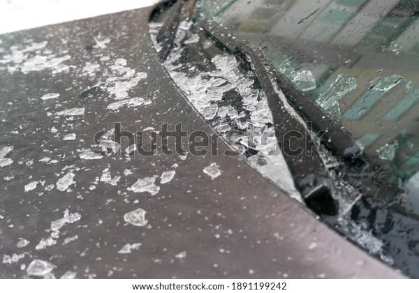 Thawed and crushed ice on the hood of\
the car near the wipers and windshield\
close-up