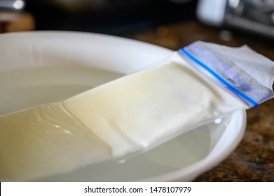 Thawing Frozen Breast Milk In Bowl Of Warm Water