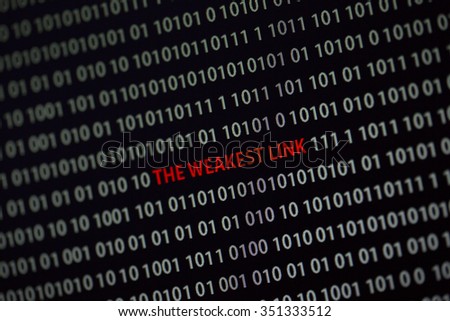 'The weakest link' text is in the middle of the computer screen surrounded by numbers zero and one. Image is taken in a small angle.
