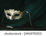 Theater arts. Venetian carnival mask against green fabric, space for text