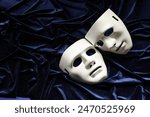 Theater arts. White masks on blue fabric, above view. Space for text