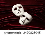 Theater arts. White masks on red fabric, above view