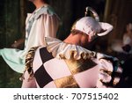 theater, clothing, dramatic art concept. close up of back of man wearing character costume for playing the role of the court jester, it has poofy sleeves, triple pleated mushroom collar and fools cap