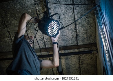 Theater lighting technician electric engineer adjusting focus of lighting elements backstage. Spotlights in the theater. Behind the scene - Powered by Shutterstock