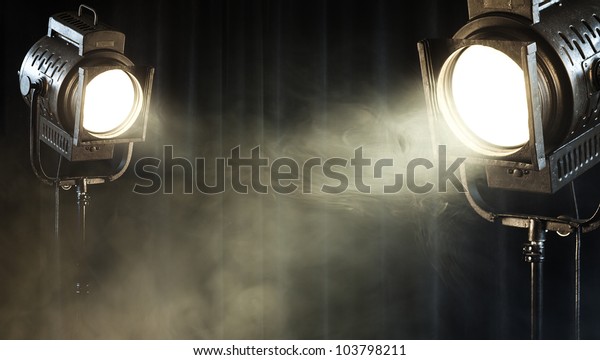 theater spot\
lights on black curtain with\
smoke