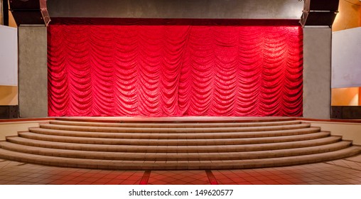 Theater stage with red curtains and steps. Theatrical scene,  the interior of the old theater of the luxury caribbean, tropical resort. Bahia Principe, Riviera Maya, Mexican Resort.