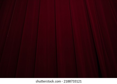 Theatrical dark red velvet curtain with golden fringe. Texture background for design.