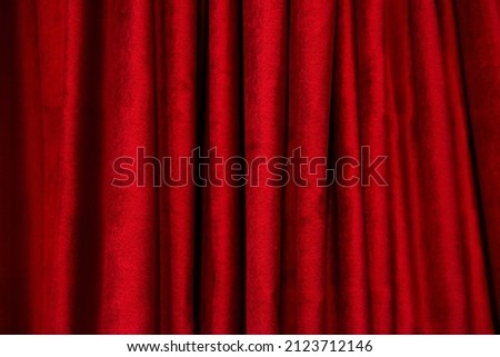 Theatrical red velvet curtain. Texture background for design. Horizontal photography.	