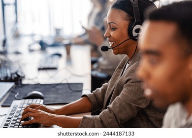 In their office, a multi-ethnic group of IT professionals works together, collaborating and using computers to accomplish their tasks - Powered by Shutterstock