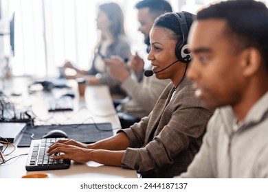 In their office, a multi-ethnic group of IT professionals works together, collaborating and using computers to accomplish their tasks - Powered by Shutterstock