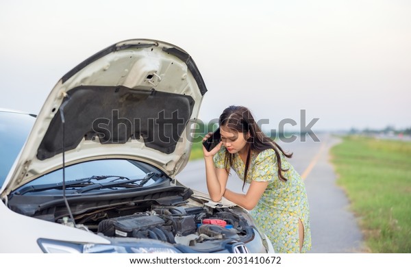 In their vacations, On
the street, there is a broken car. lady inspecting car dents and
scratches