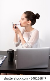 Thel Pretty Young Lady Corrects A Make-up Behind A Workplace, Beautiful Businesswoman Applying Lipstick Using Lip Concealer Brush In The Office.