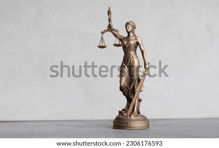 themis goddess of justice statuette on light gray background. symbol of law with scales sword in hands. legal company or university of law and judicial structure. court acquittal of the verdict