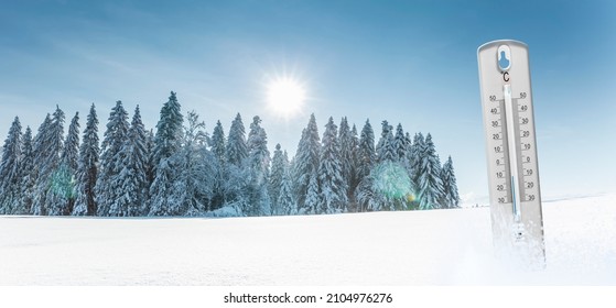 Themometer with minus temperatures in Celsius in front of a winter landscape